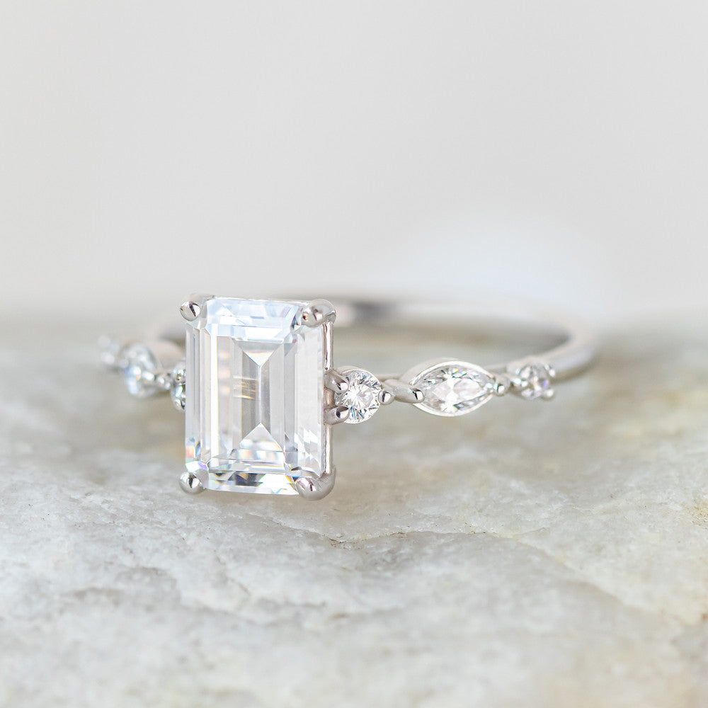 Coco emerald cut side stone engagement ring