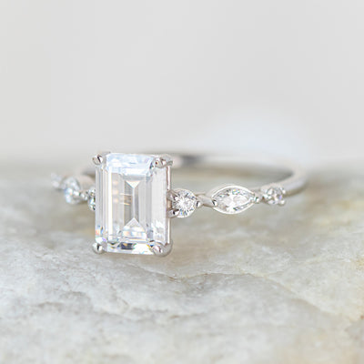 Coco emerald cut side stone engagement ring